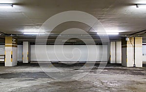 Parking garage underground interior with blank billboard.Empty space car park interior at afternoon.Indoor parking lot.
