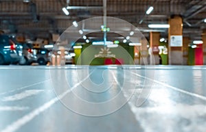 Parking lot cars blurred. Car lot parking space in underground city garage. Empty road asphalt background in soft focus