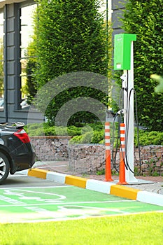 Parking lot with EV Car or Electric car charging station. Eco-friendly alternative energy