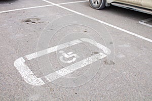 Parking lot with handicap sign and symbol. Empty reserved parking space with wheelchair symbol. Disabled person sign