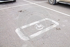 Parking lot with handicap sign and symbol. Empty reserved parking space with wheelchair symbol. Disabled person sign