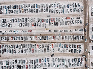 Parking lot with many cars near mall or shopping center in winter with snow, aerial view, drone photo