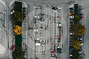 Parking lot and parked colorful cars between the lines from above (top view)