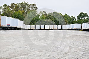 Parking lot of semi-trailers in a gravel parking lot