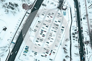 Parking lot at winter season with snow-covered cars. aerial photo with drone