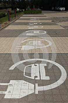 Parking lots for electric cars only. Charging stations stand in a row. Electric car sign