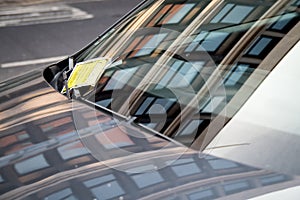 Parking penalty fine charge notice on car windscreen.  Yellow notice issued by Newcastle City Council