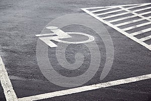 Parking spaces with lines of signs for disabled people on asphalt