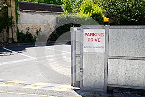 Parking prive sign text in french door steel portal open means parking private forbidden acces sign