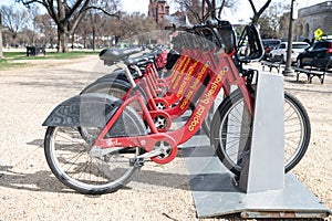 Parking for rental bikes in central Washington. A number of fixed red bicycles for rent in a mobile application