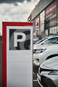 A parking sign at a car dealership close-up and the cars