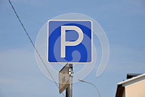 Parking sign at house on blue sky background