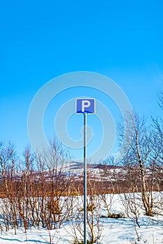 Parking sign with mountains and blue sky in the background