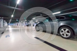 Parking space blurred. Empty road asphalt background in soft focus. Car lot parking space in underground city garage. Hidden