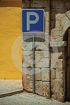 PARKING SPOT road sign in front of plaster yellow wall