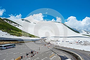 Parking spot for tourists snow mountains wall of Tateyama Kurobe alpine with blue sky background is one of the most important