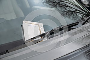 Parking ticket stuck on car windscreen for a penalty or fine.