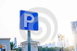 Parking traffic road sign on the right side and background of blue sky. Paid parking sign. Blurred background