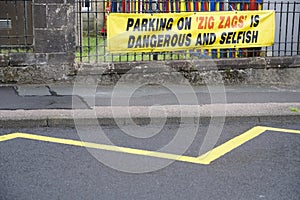 Parking on zig zags is dangerous and selfish sign outside school for children road safety photo