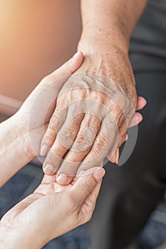 Parkinson disease patient, Alzheimer elderly senior, Arthritis person`s hand in support of nursing family caregiver care