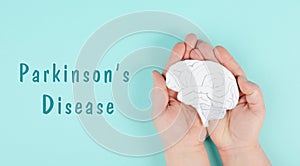 Parkinson`s disease is standing on a paper, hands holding brain, dementia diagnosis, Alzheimer