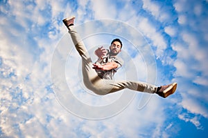 Parkour guy jumping below blue sky