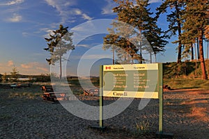 Parks Canada Sign at Gulf Islands National Park in Evening Light, Sidney Spit, British Columbia photo
