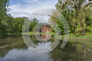 Parks pond on spring day with small brick chapel afar