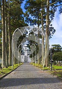 Parkway with small white and gray church of Sao Nicolau at the village of Sete Cidades on the island of Sao Miguel