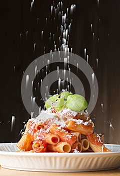 Parmesan cheese on the macaroni with tomato sauce