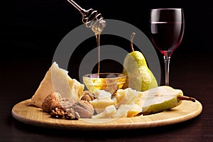 Parmesan cheese pears honey walnuts and wineglass photo