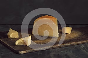 Parmesan cheese, sliced and pounded on a dark background