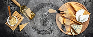 Parmesan. Cheeses set dor blu chedar camamber brie. Different types of cheese with knife on a dark background. Long banner format