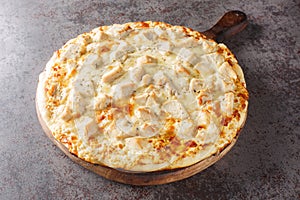 Parmesan Crusted Chicken Alfredo Pizza closeup on the wooden board. Horizontal