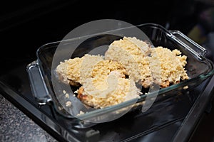 Parmesan crusted chicken breast being cooked ready for the oven