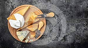 Parmesan. Different types of cheese with knife on a dark background. Cheeses set dor blu chedar camamber brie. place for text, top