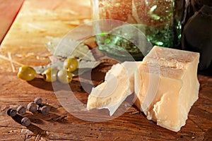 Parmesan and olives on wooden surface