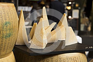 Parmesan is on table for sale on the market. Parmigiano-Reggiano is made from unpasteurized cow`s milk