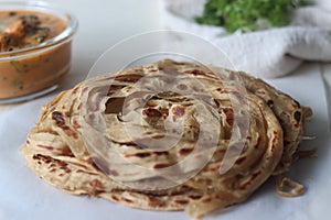 Parotta or Porotta, a layered flatbread made of Maida. This flaky ribbon pancake is a favourite of Kerala. Shot with Butter