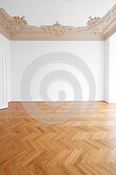 Parquet floor , white walls and stucco ceiling in empty room after renovation