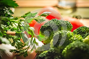 Parsley and broccoli with tomatoes in the background