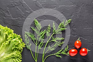 Parsley, dill, cabbage leaves, pepper on a dark concrete background. Fresh products for salads and vegetarian food.