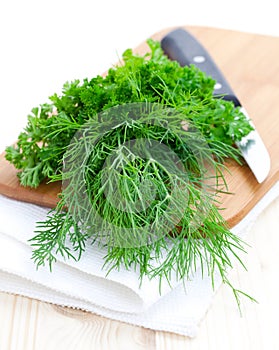 Parsley and dill on cutting board