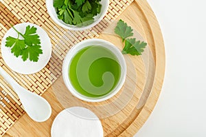 Parsley juice and cotton pads. Ingredients for preparing homemade eye mask or face toner. Natural beauty treatment recipe