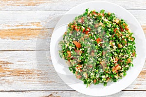 Parsley salad or Tabbouleh on white platter photo