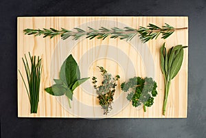 Parsley, thyme, and rosemary on chopping block for nutrition, health and adding flavour to food. Green herbs, basil and