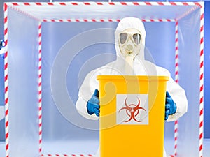 Parson in protective suit holding biohazard waste