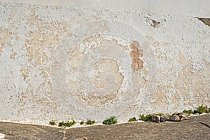 Part of abandoned white paint cracked stucco wall.