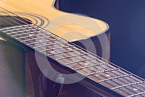 Part of acoustic guitar on black background copy space