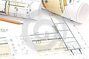 Part of architectural project with rolls of blueprints and pencil